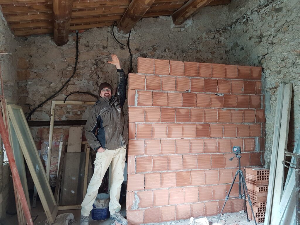 Paolo posing next to a brick wall