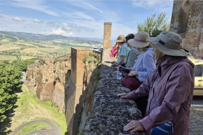 On a guided tour of orvieto - people overlooking wall