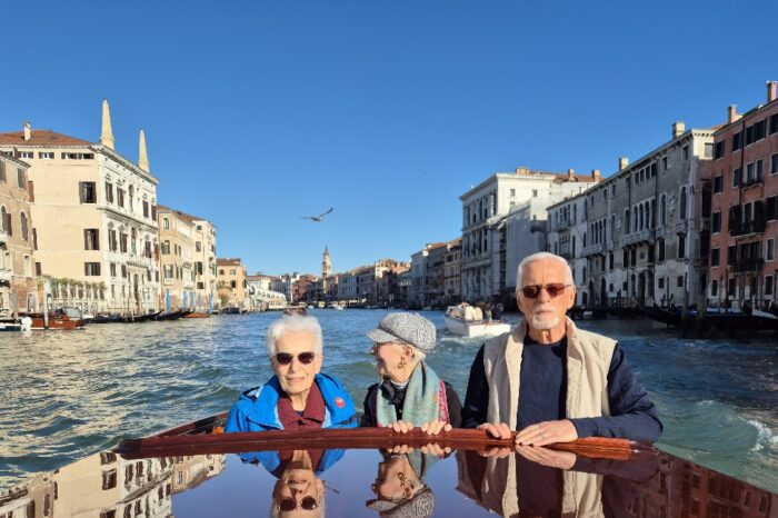 Tour Group Streaming Down Venetian Canal on a Water Taxi