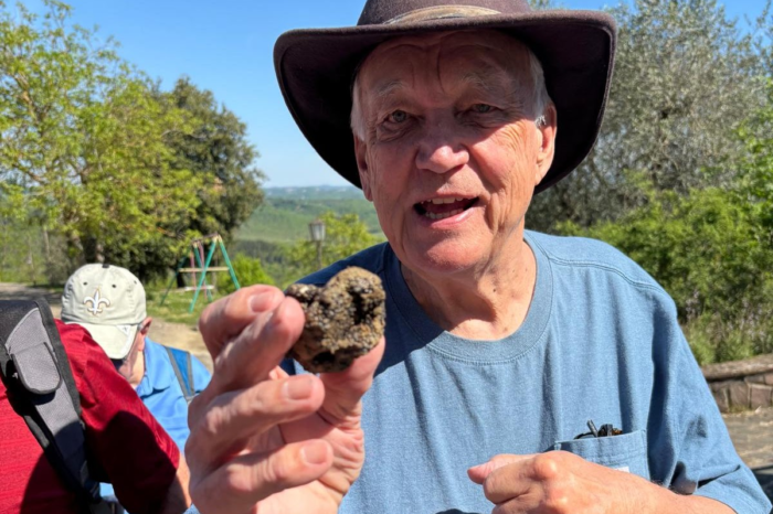 man with a hat holding a black truffle